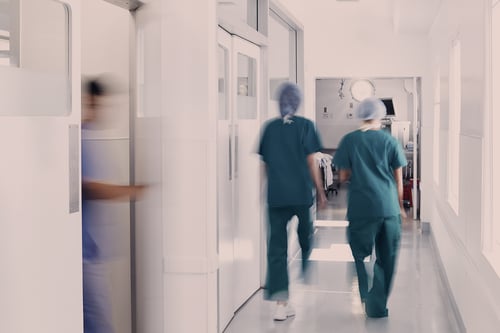 Kaksi hoitajaa kävelee sairaalan käytävällä.